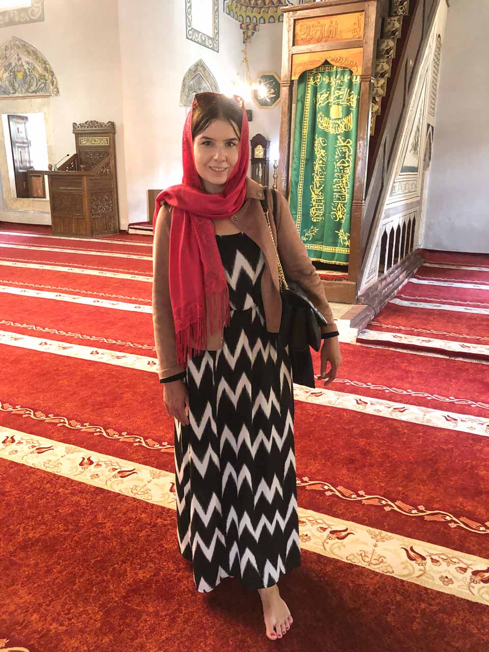 Woman wearing a pink headscarf inside the Sinan Pasha Mosque in Prizren, Kosovo