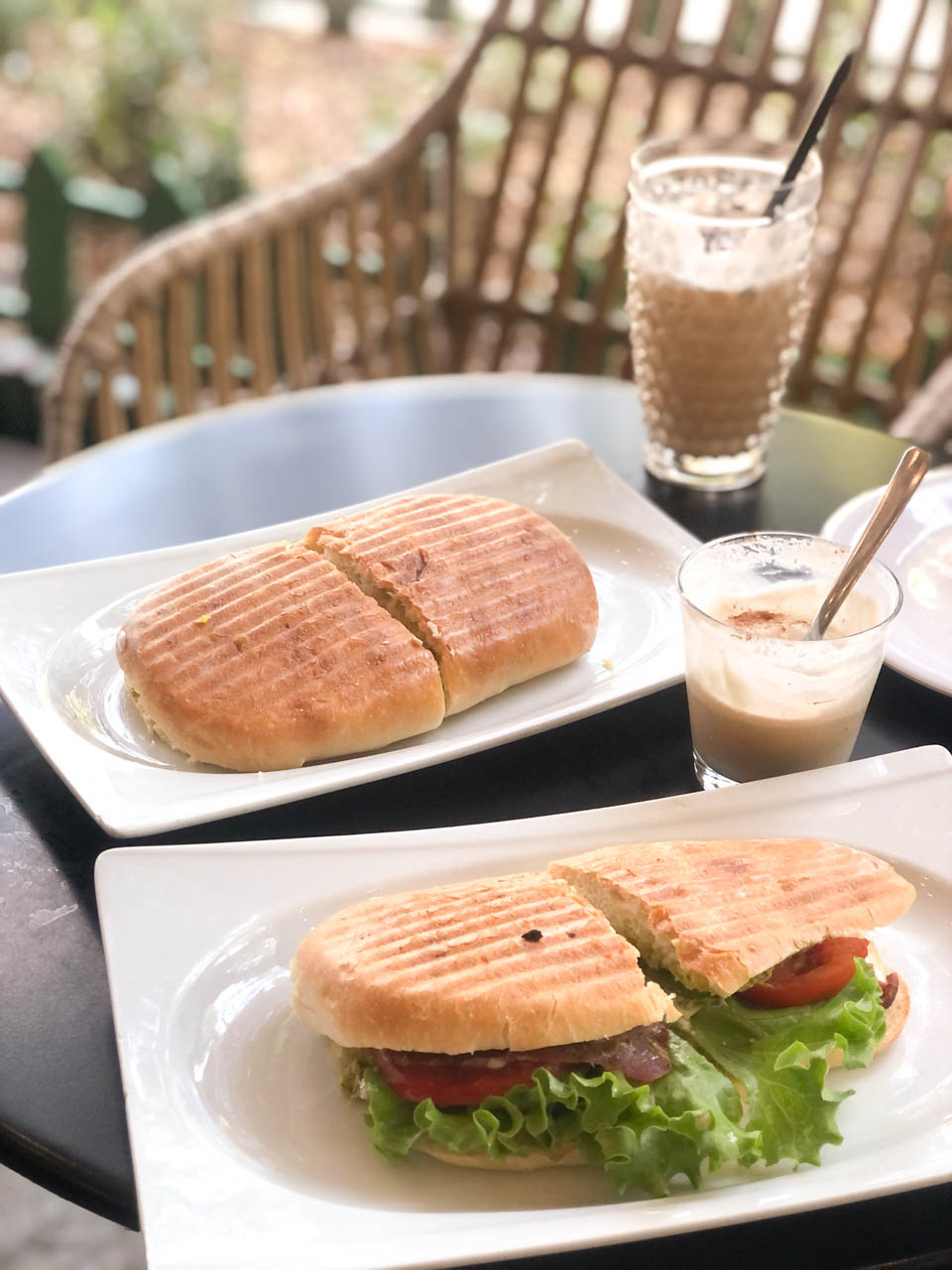 Two paninis and two cups of coffee on a table