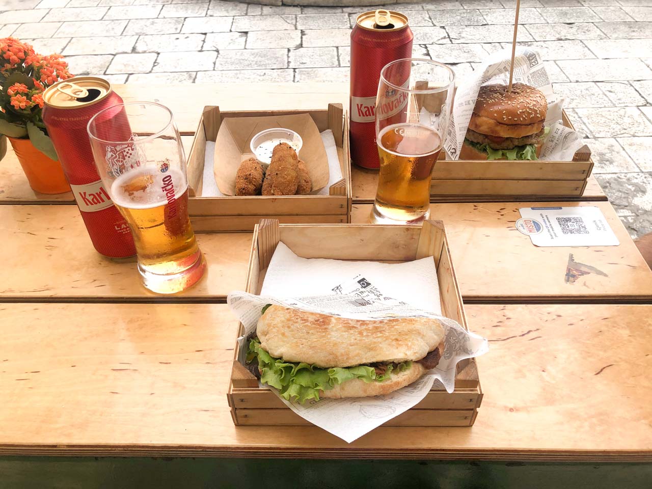 Dalmatian food and Karlovačko beer on a table outside Misto - Street Food & Bar in Split Old Town