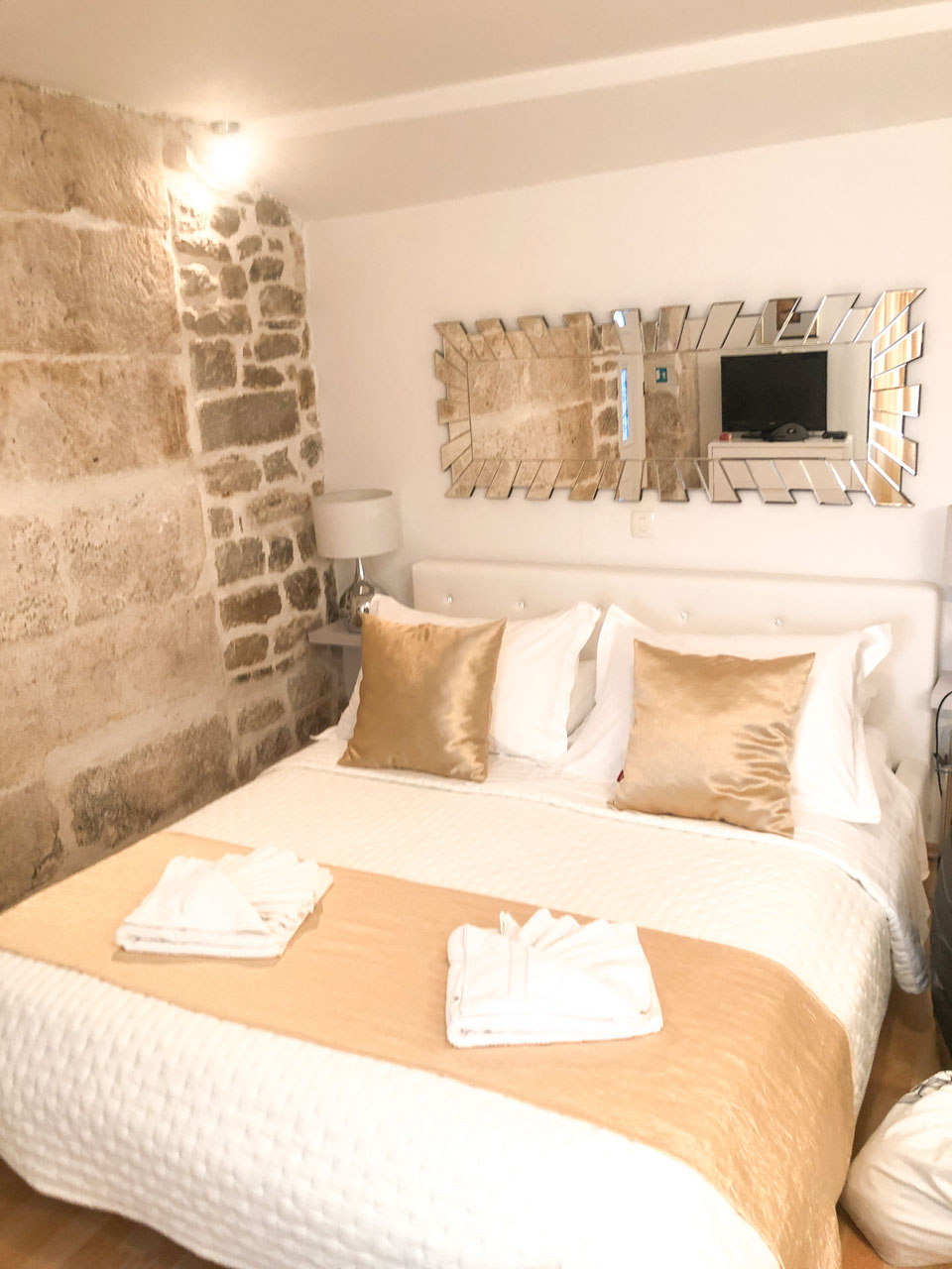 Bed with golden pillows in a flat inside the former Diocletian's Palace in Split Old Town