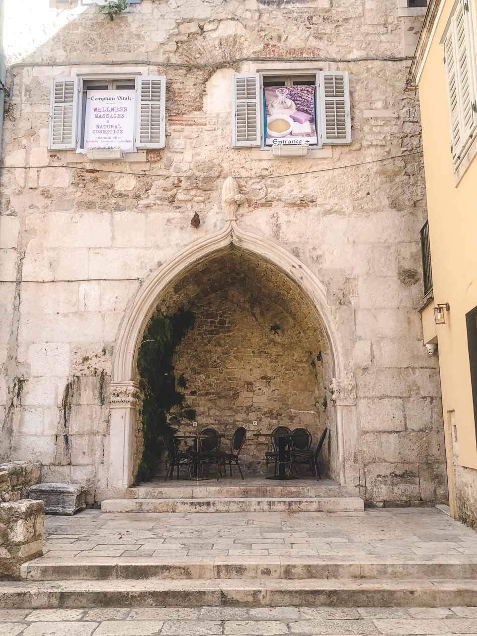 Tables under a stone arch in Split Old Town