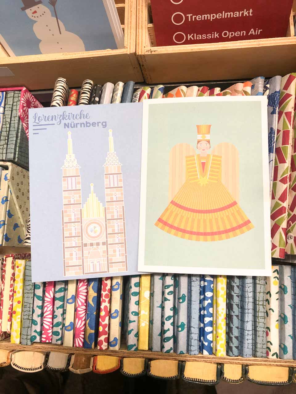Festive Christmas cards on display at a Nuremberg market stall, featuring the Lorenzkirche and the Rauschgoldengel