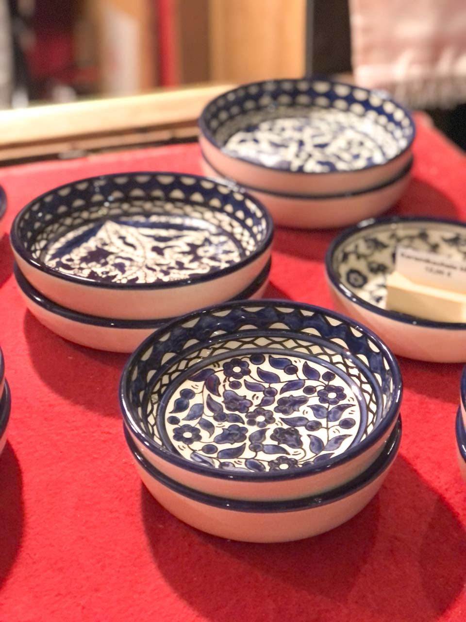 A collection of hand-painted blue and white ceramic bowls, featuring intricate patterns, available at a crafts stall at the Nuremberg Christmas Market