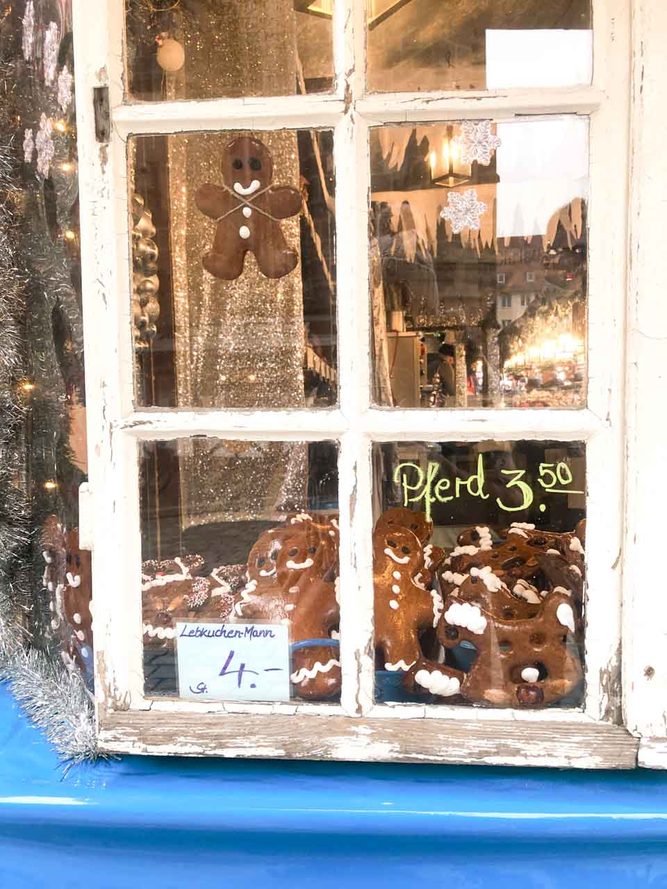 Handmade gingerbread men decorated with white icing, displayed in an old-fashioned shop window at the Nuremberg Christmas Market