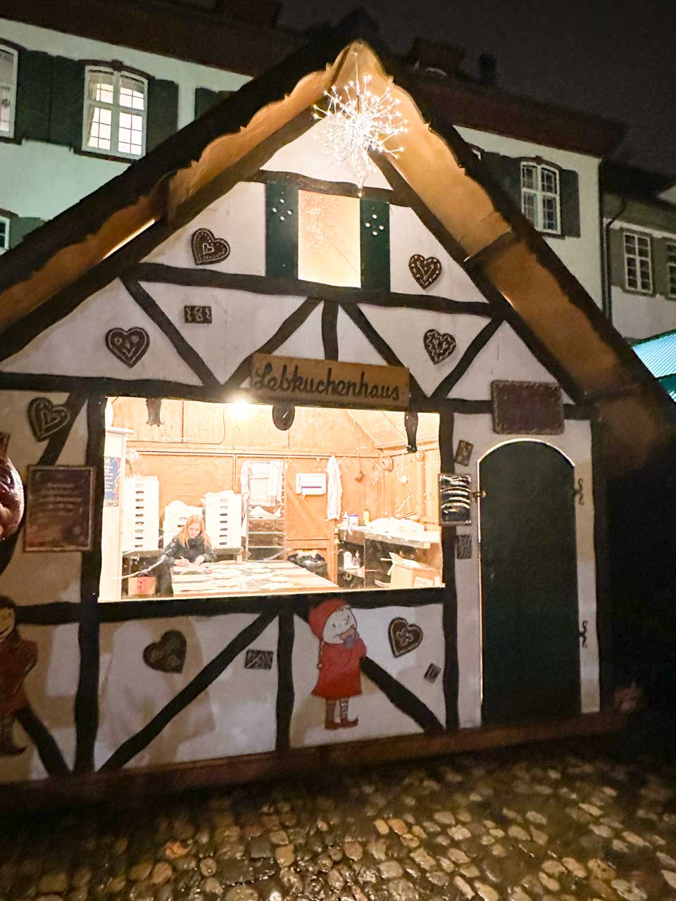 A gingerbread house stall at the Basel Christmas market with a large snowflake decoration