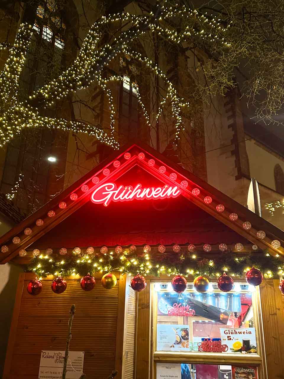 A cosy mulled wine stall at the Basel Christmas market on Barfüsserplatz, illuminated by twinkling lights and festive decorations