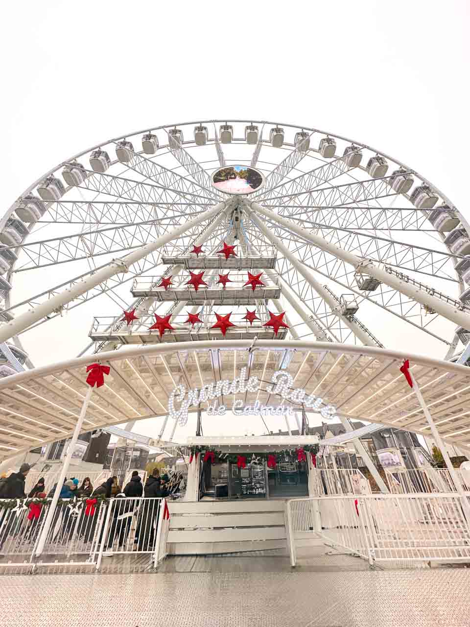 Grande roue de Colmar - a Ferris wheel adorned with white stars and festive red bows