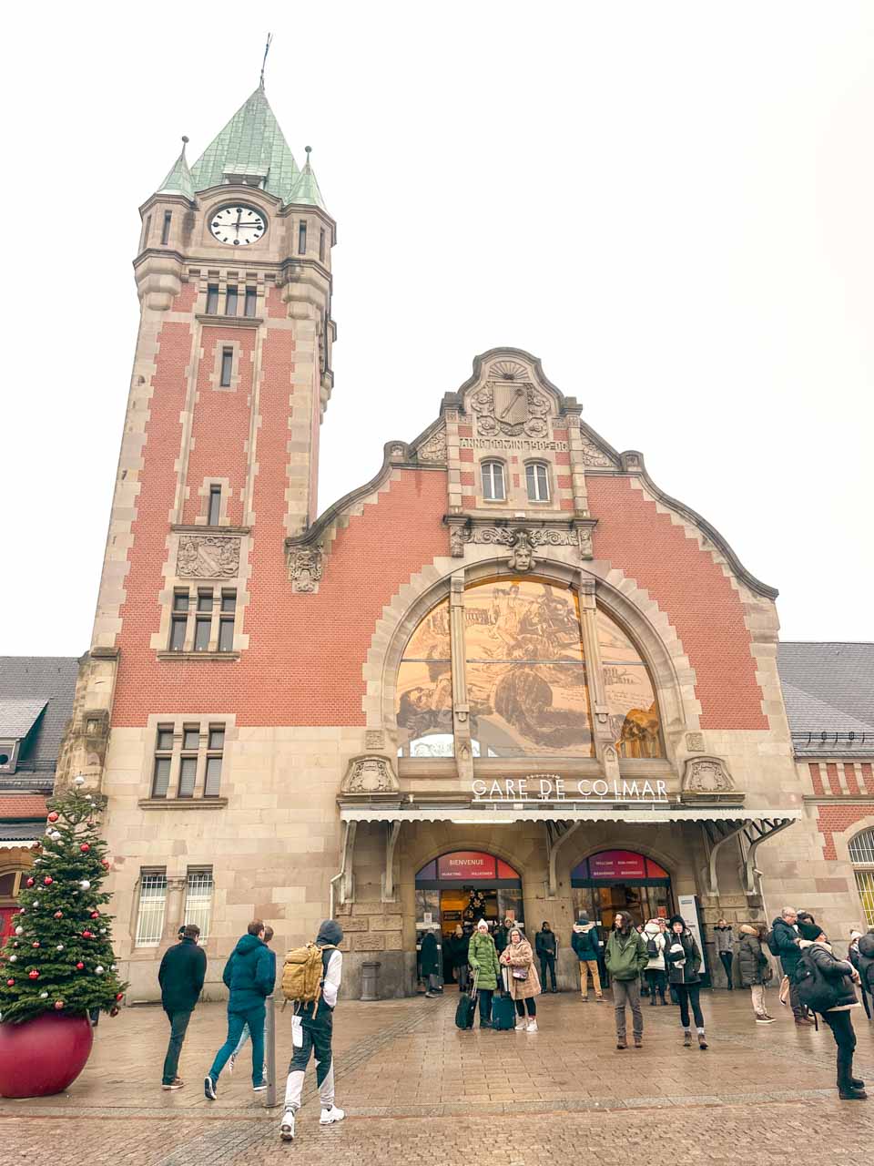 The front of Colmar train station, with its grand clock tower and festive decorations