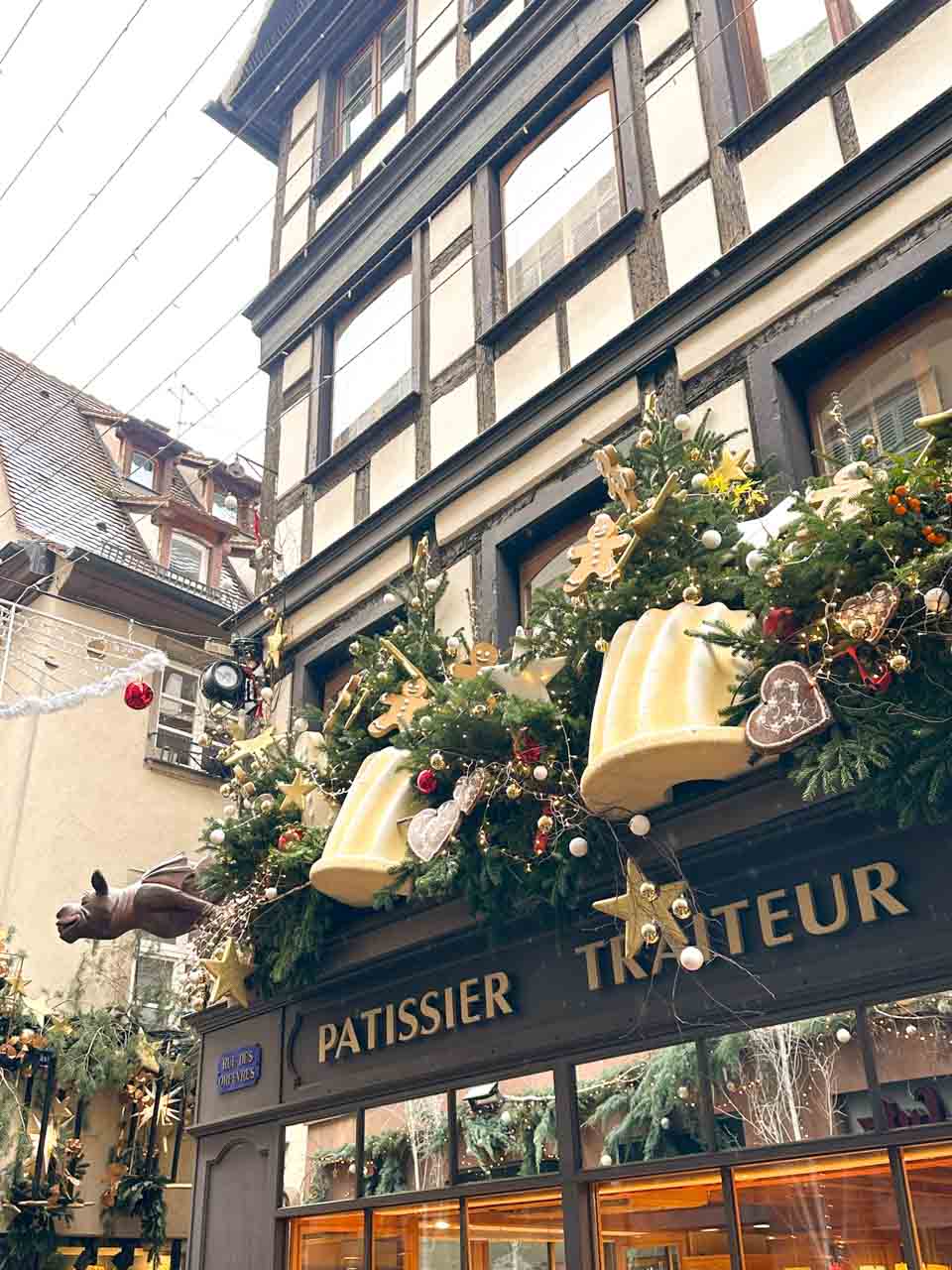 A patisserie in Strasbourg festively decorated with Christmas greenery, ornaments, and gingerbread men