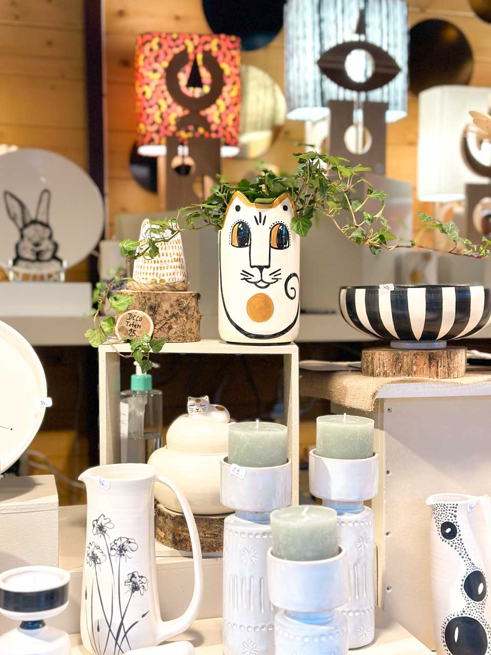 A collection of artistic pottery and candles, featuring charming animal designs, on display at a Christmas market stall in Strasbourg