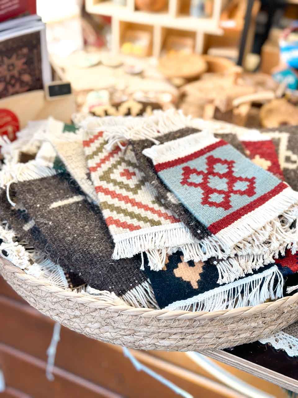 A basket filled with woven handcrafted mittens, showcasing traditional Armenian patterns and designs, at a Christmas market stall in Strasbourg