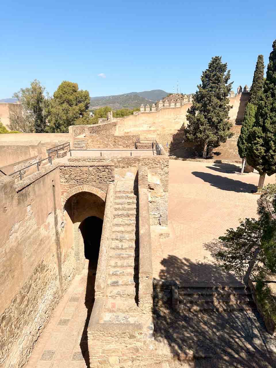 A walkway leading through a brick archway inside the Gibralfaro Castle in Malaga, Spain