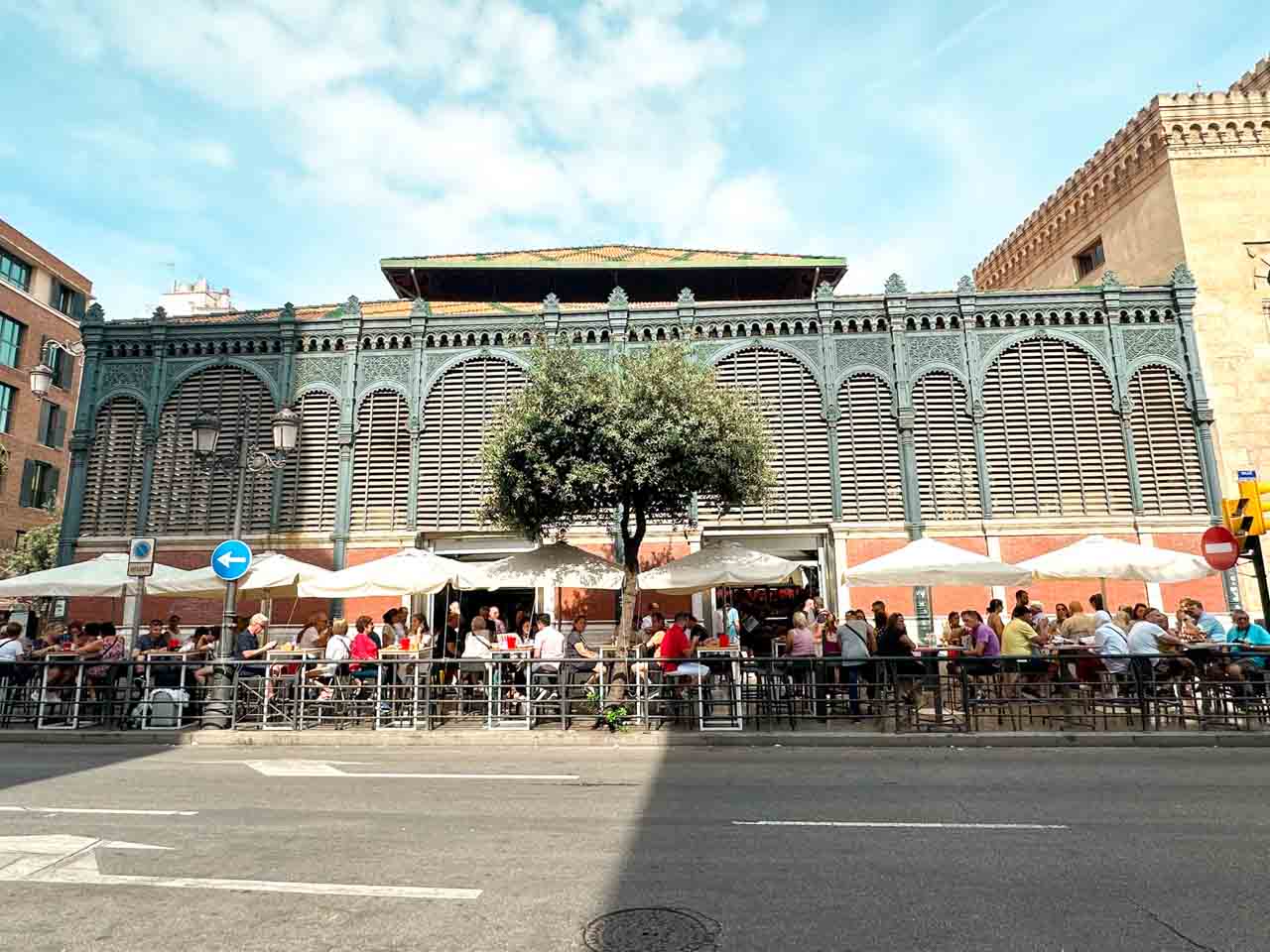 People sitting outside the Atarazanas Market in Malaga, Spain
