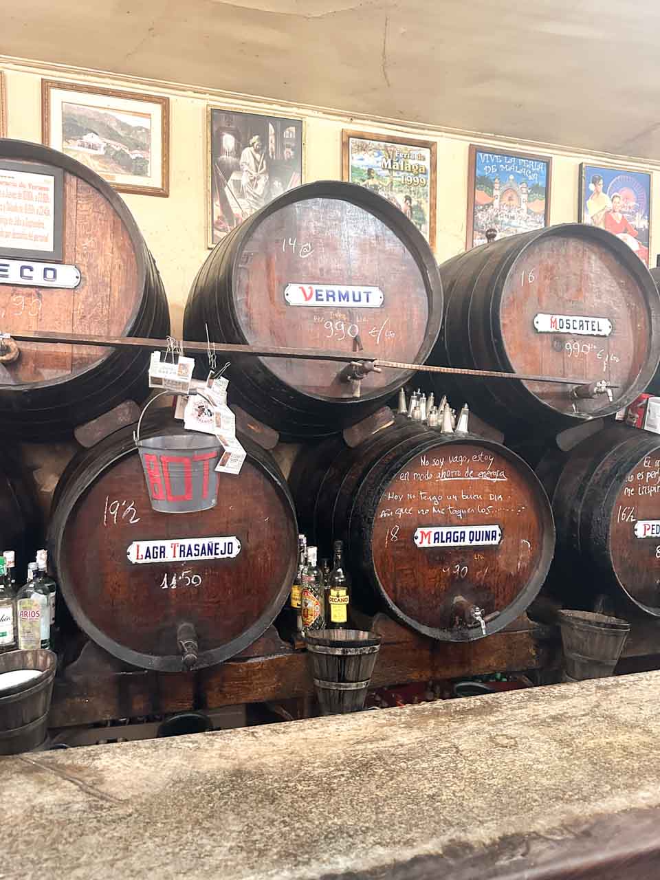 Wooden wine barrels labelled with various types of Spanish wines and vermouths at Antigua Casa de Guardia in Malaga, Spain