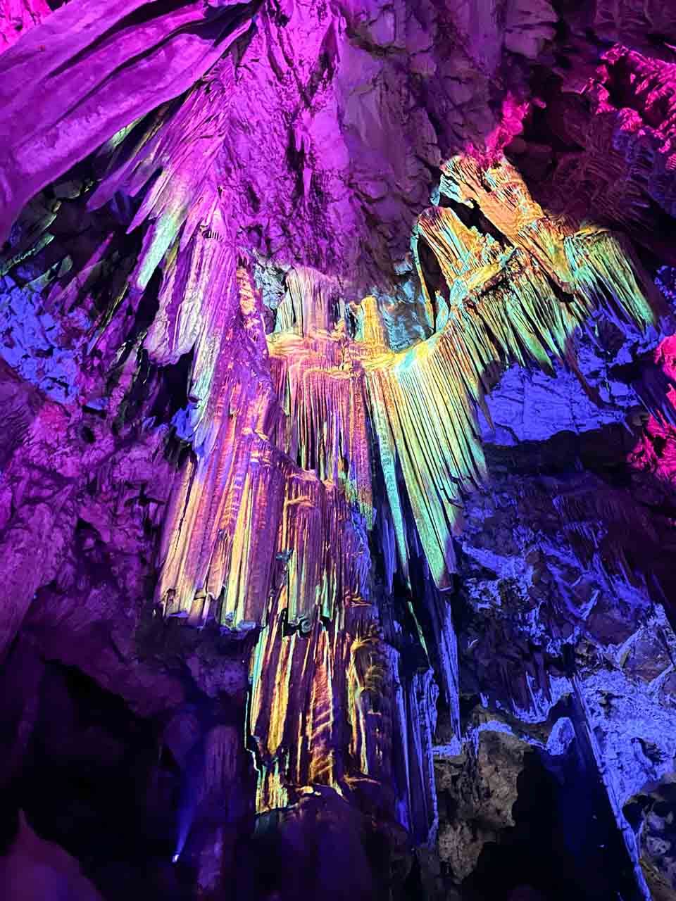 Stalactites and stalagmites illuminated by colourful lights inside St. Michael's Cave in Gibraltar