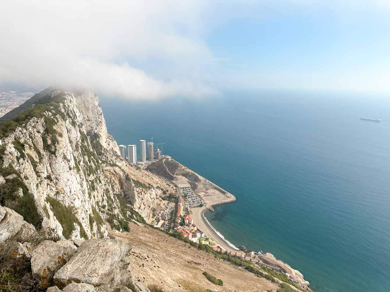 Rock of Gibraltar partially covered by the clouds, surrounded by water