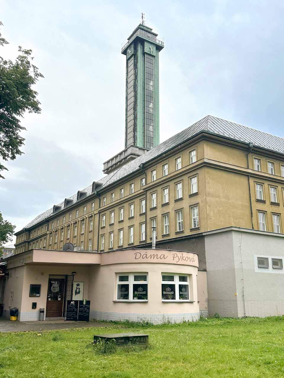 Entrance to the Dáma Pyková Restaurant in Ostrava with the observation tower of the New City Hall in the background