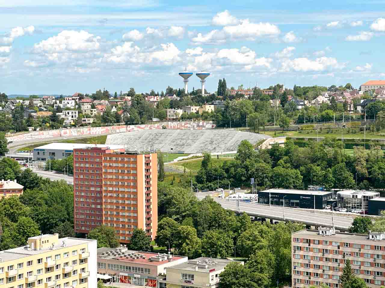 Aerial view of the old stadium of FC Baník Ostrava, residential buildings, and unique water towers in the distance from the New City Hall Observation Tower