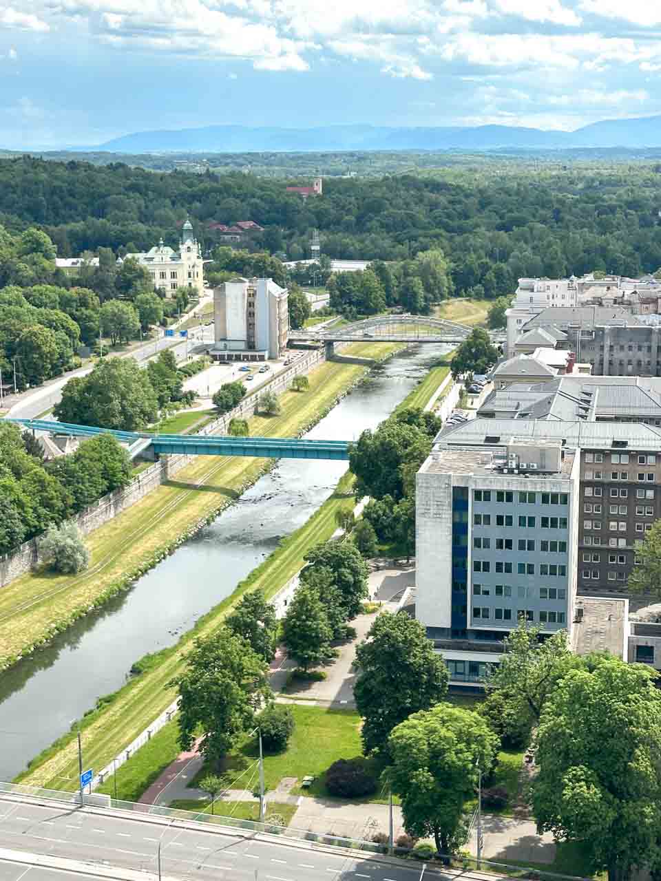 View of Ostravice river with the Miloš Sýkora bridge, surrounded by modern buildings and extensive green areas seen from the New City Hall Observation Tower