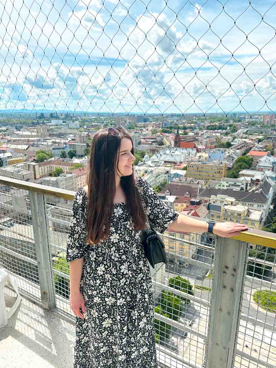 Woman looking over Ostrava from the New City Hall Observation Tower, behind safety netting