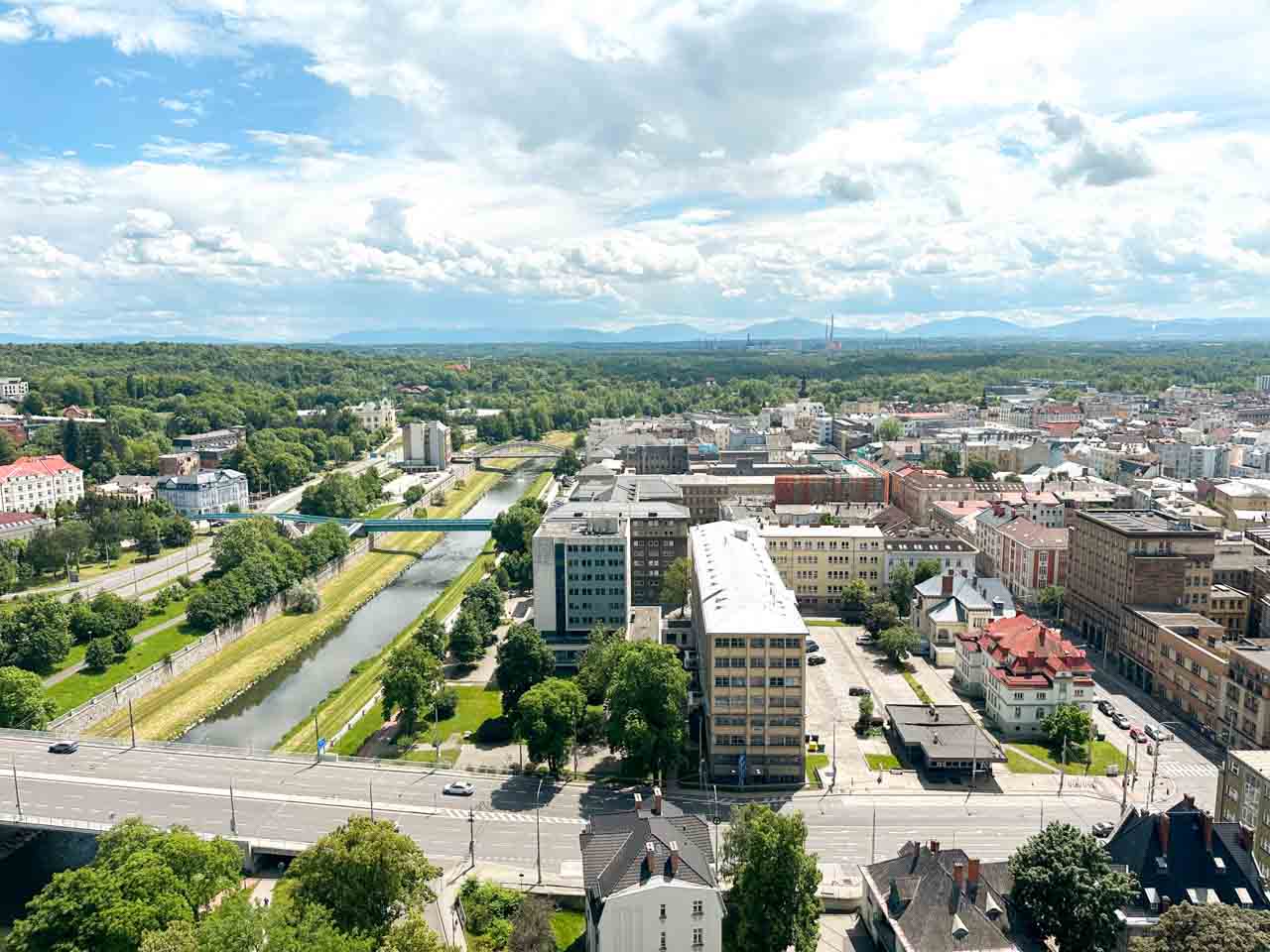 View from above of a river winding through Ostrava with lots of greenery and buildings