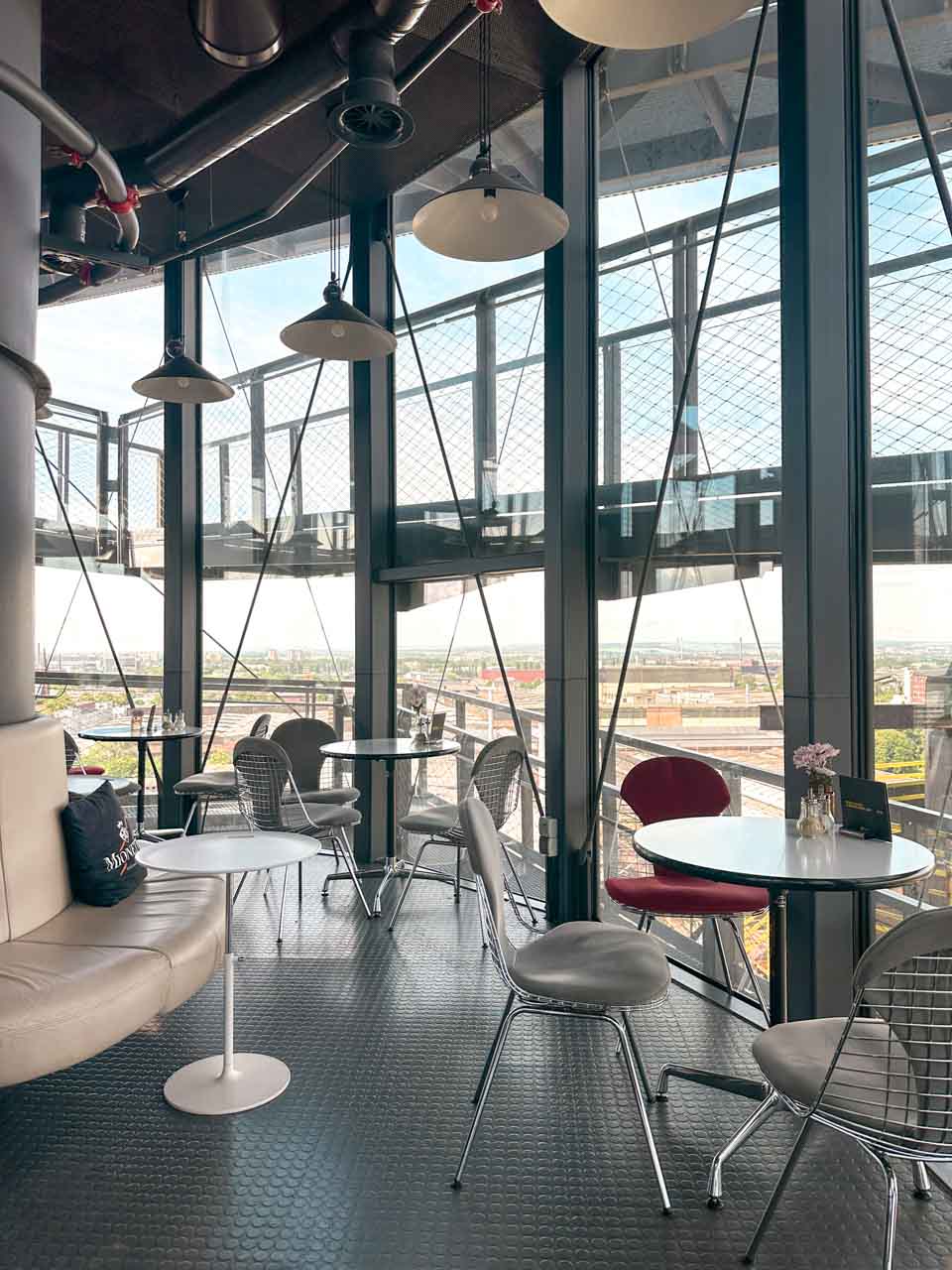 The interior of Ostrava's Bolt Cafe with industrial views through large windows