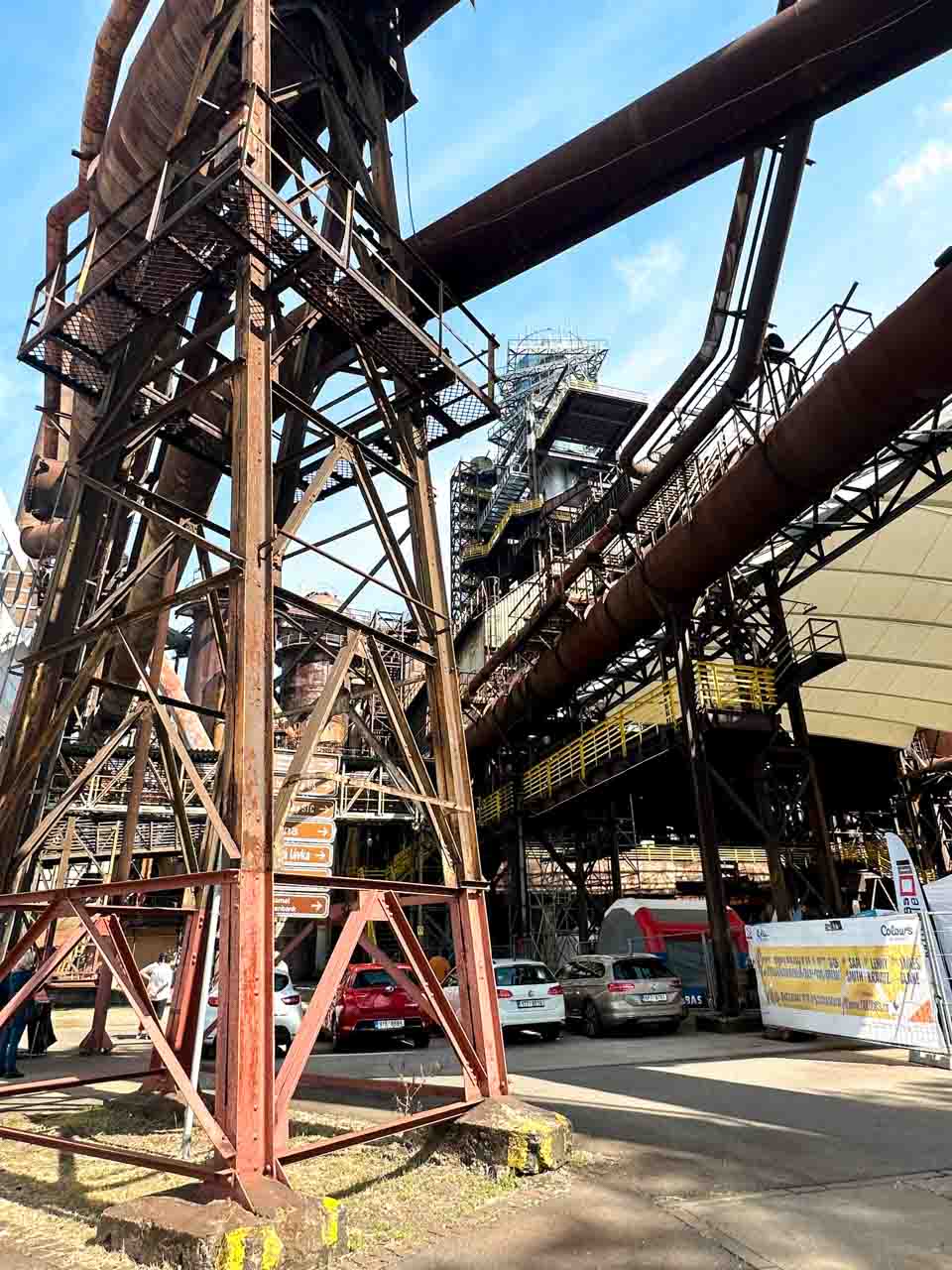 View of the Dolní Vítkovice industrial plant with large pipes and structures under a blue sky