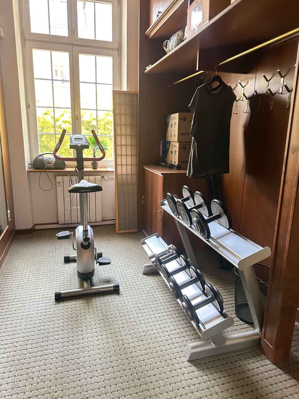 Small gym area with exercise machines and weights inside the Retro Hotel Villa Ostrava