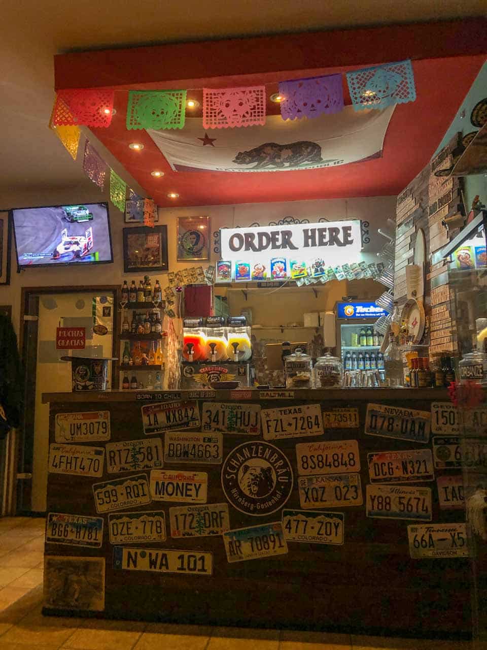 A quirky food counter decorated with colourful flags and number plates at Crazy Nate's in Nuremberg, Germany