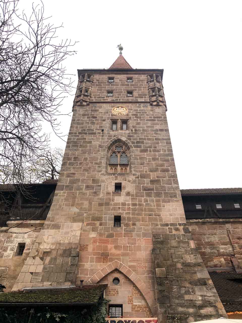 A close-up view of a tall medieval stone tower at Nuremberg Castle