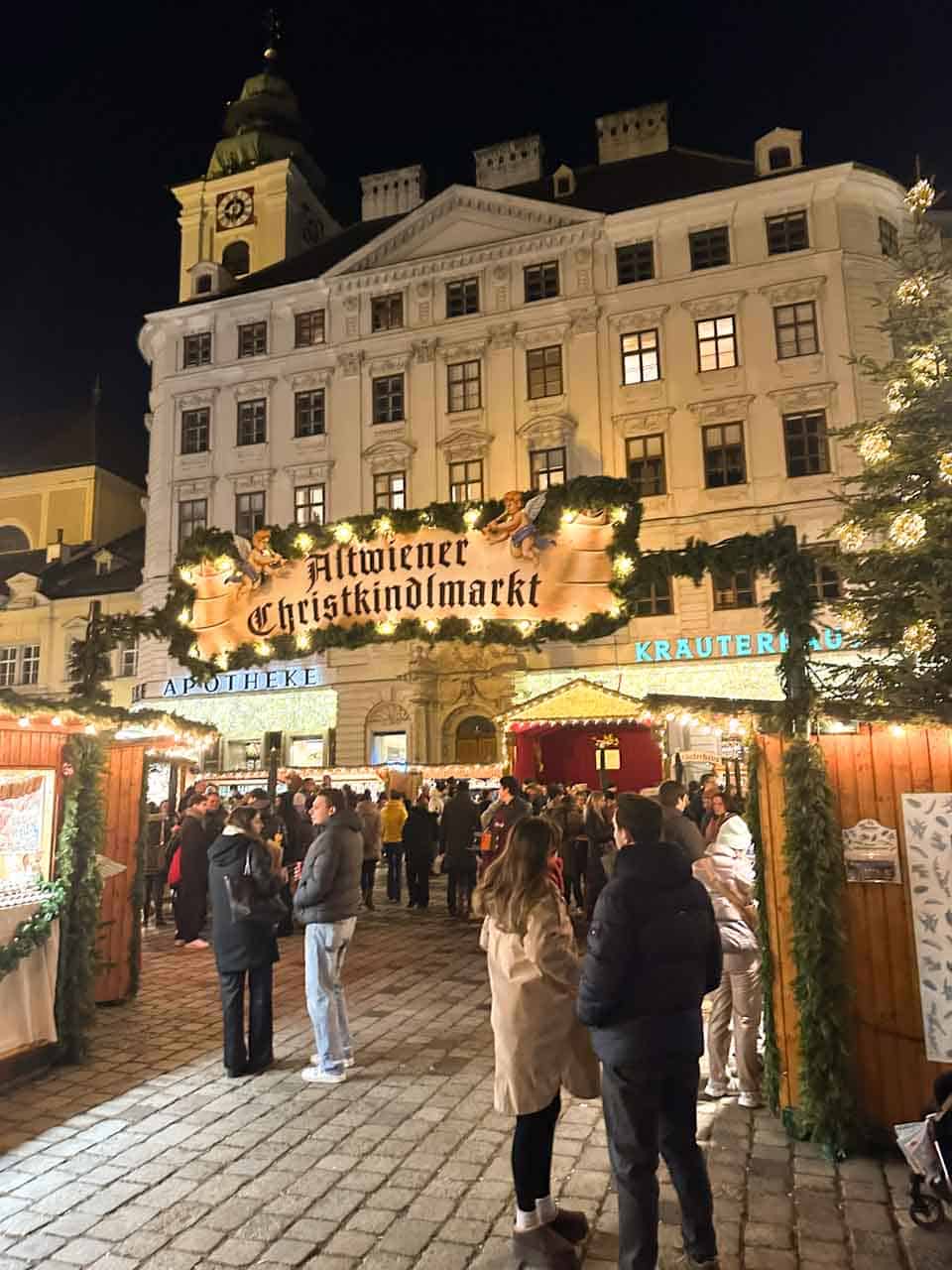 People enjoying the festive stalls at the Alt-Wiener Christkindlmarkt in Vienna