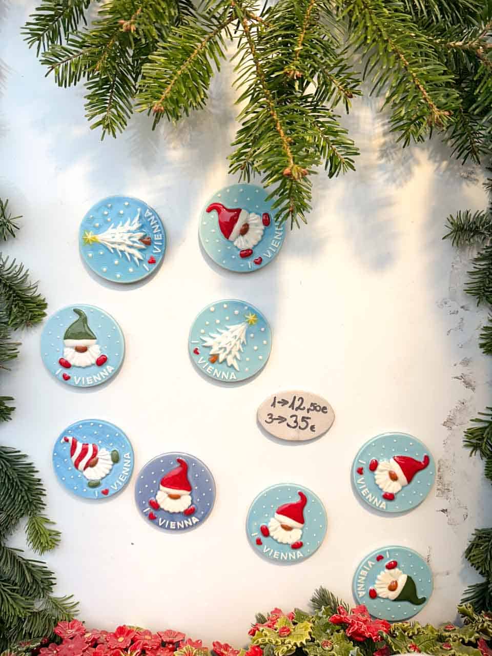 Round Vienna-themed ceramic magnets with festive designs on display at the Schönbrunn Christmas market in Vienna