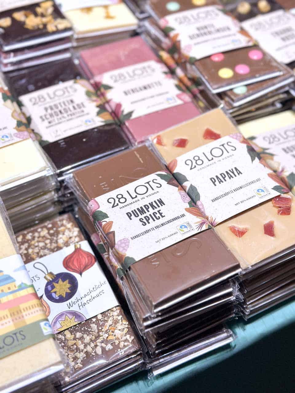 A colourful selection of handmade chocolate bars, including flavours like pumpkin spice and papaya, displayed at one of the Vienna Christmas markets