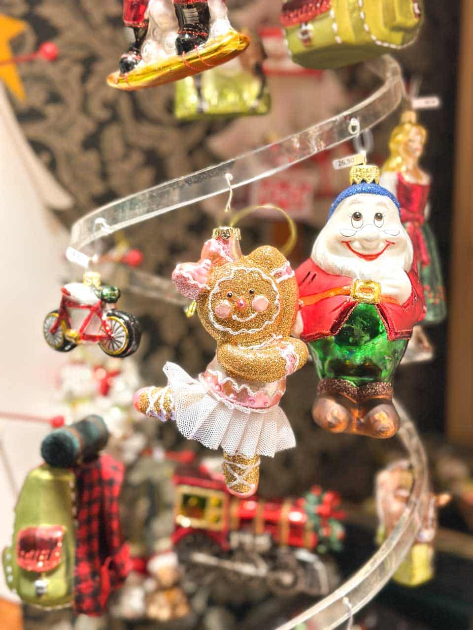 Glass ornaments, including a gingerbread ballerina and a cheerful Humpty Dumpty figure, displayed on a rotating stand