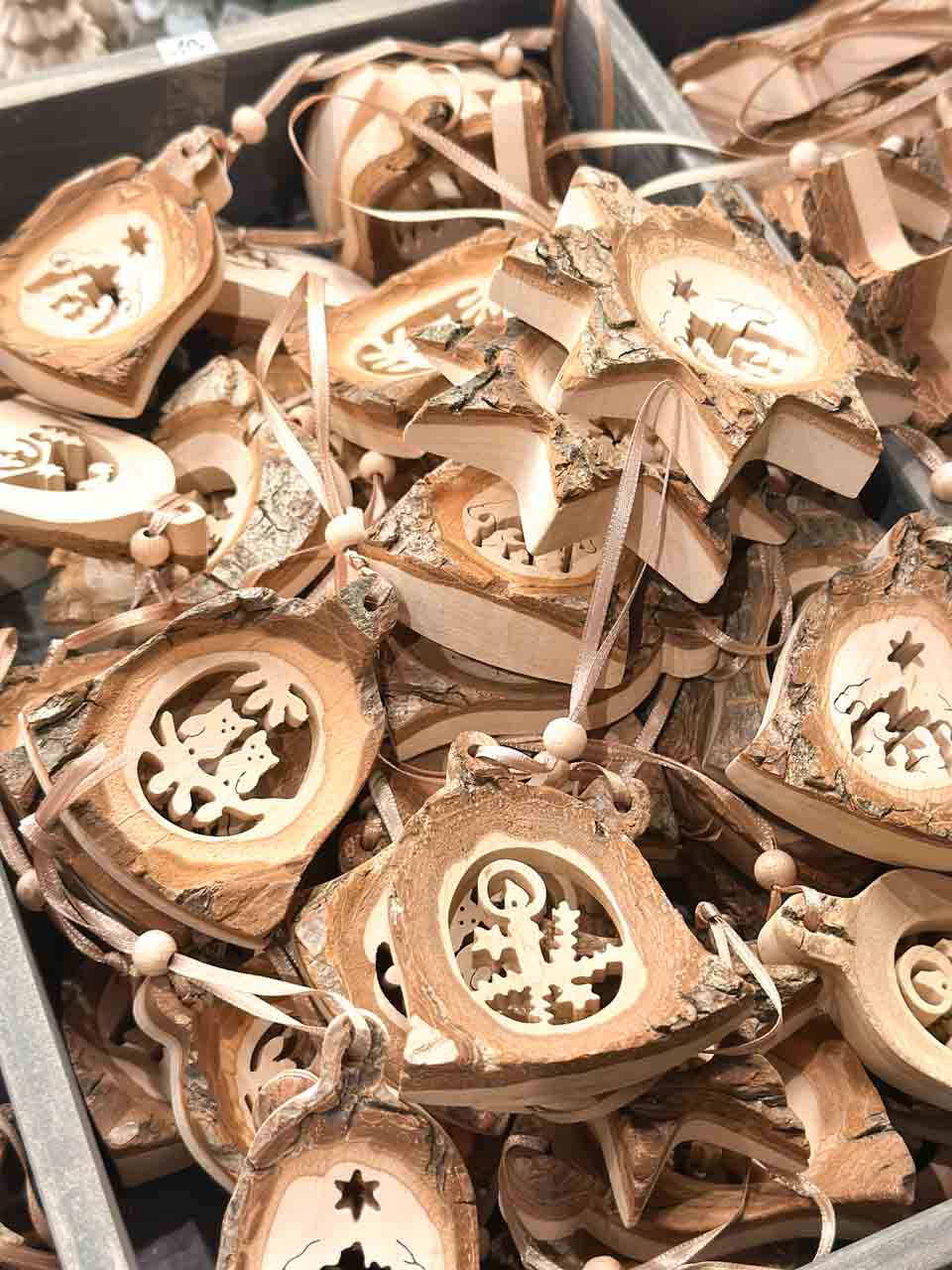 Wooden Christmas decorations with intricate cut-outs of stars, trees, and snowflakes
