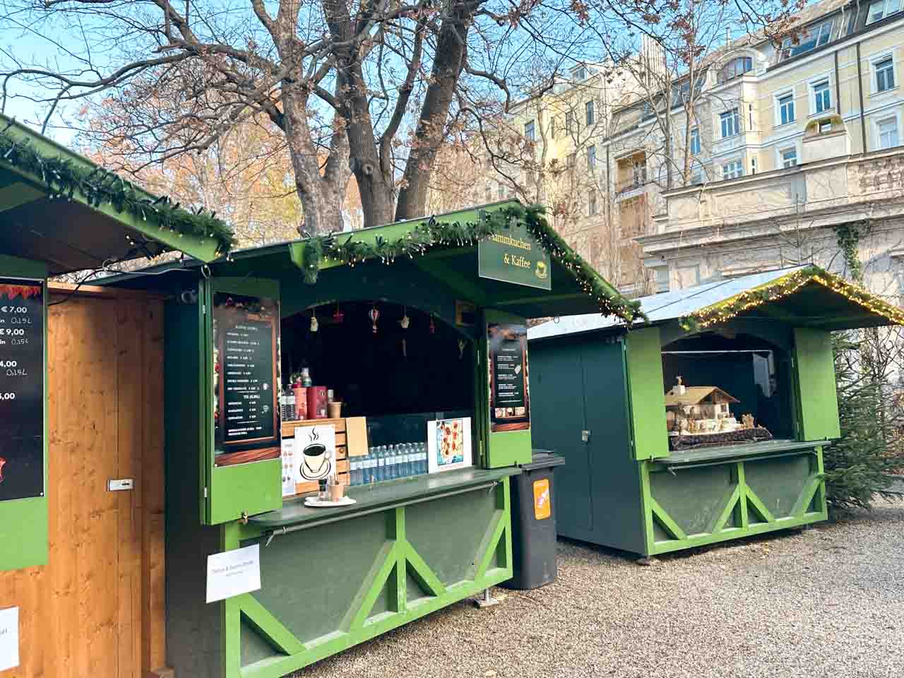 Festively decorated green market stalls at the Advent im Gartenpalais Liechtenstein Christmas market in Vienna