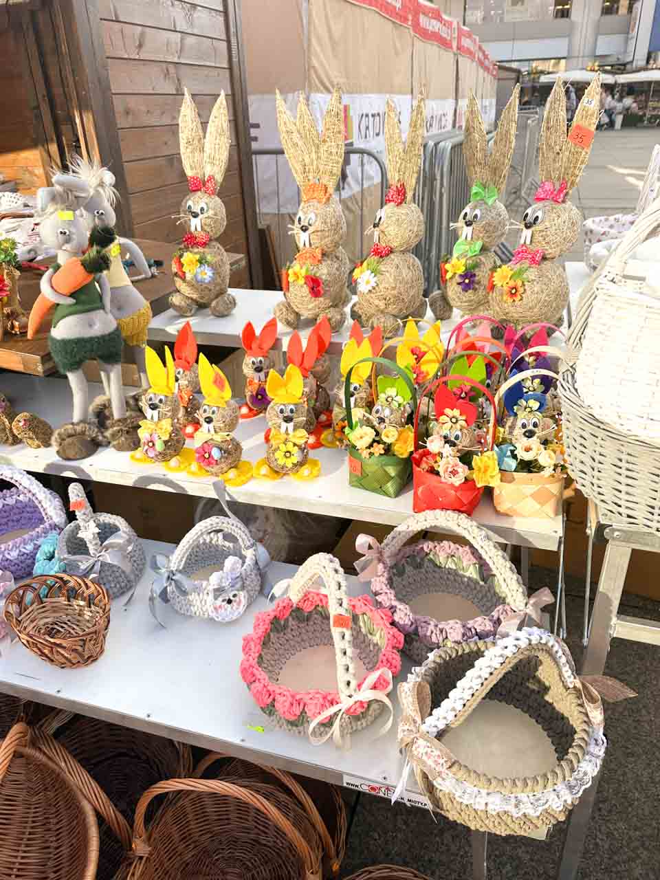 A stall full of handmade Easter decorations, including straw bunnies, baskets, and colourful spring ornaments at the Katowice Easter Market