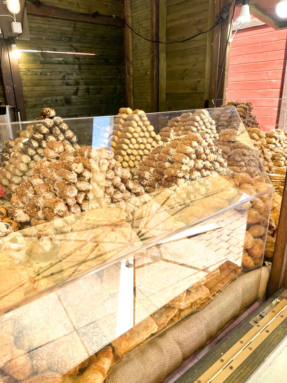 Pyramids of cannolis and other Italian pastries behind a glass counter at an Easter market stall in Katowice, Poland