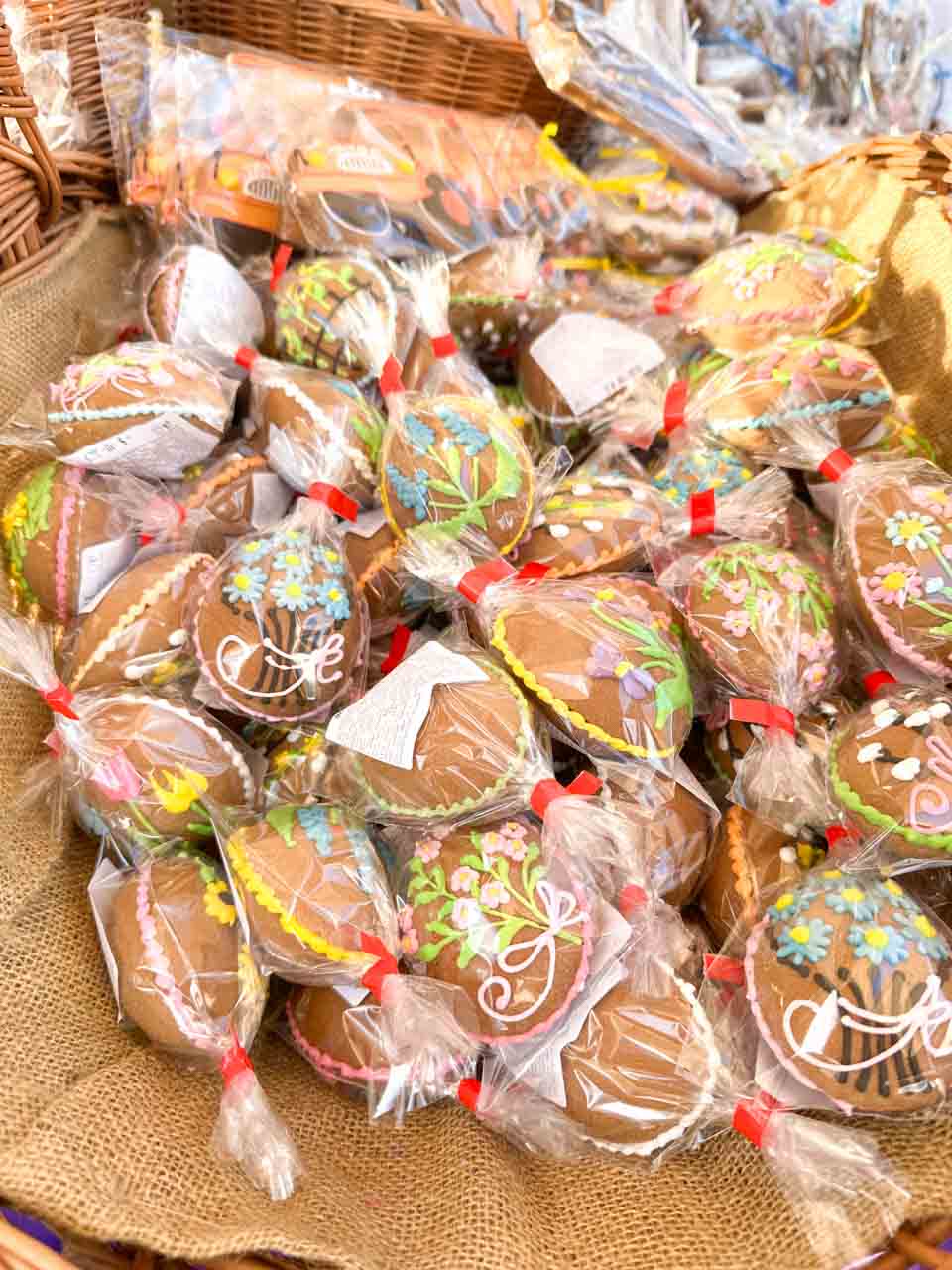 Egg-shaped gingerbread cookies with colourful icing, wrapped in clear bags and tied with red ribbons, on display at the Katowice Easter Market