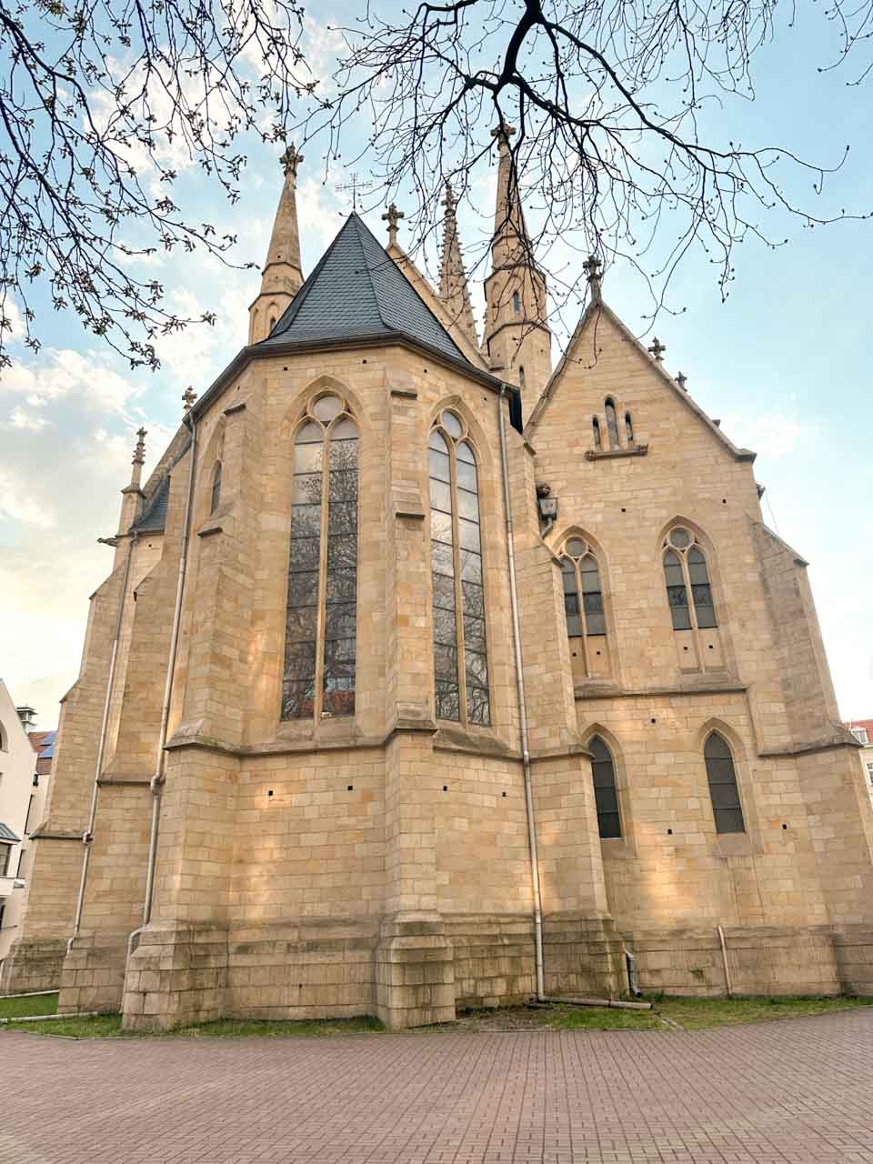 The back view of the Immaculate Conception of the Blessed Virgin Mary Church in Katowice, with tall pointed windows and spires reaching into the sky