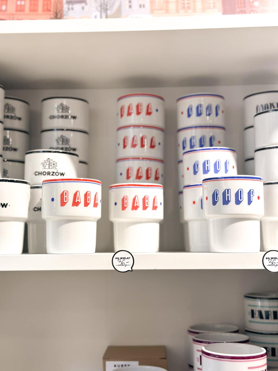 A shelf display of white mugs labelled &ldquo;BABA&rdquo; and &ldquo;CHOP&rdquo; in bold red and blue lettering