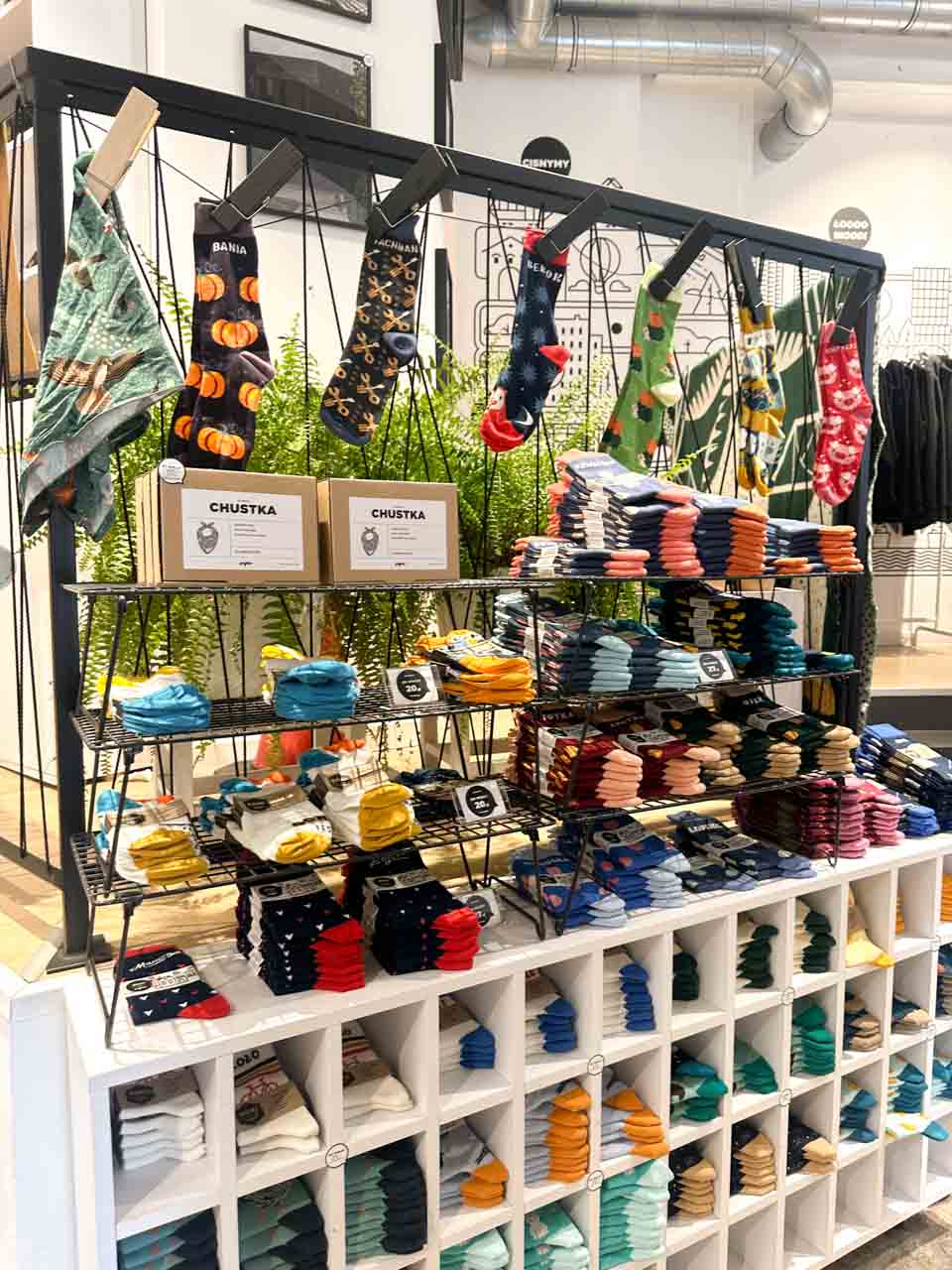 A display of colourful socks and scarves inside the Gryfnie shop in Katowice, with patterned pairs hanging above neat stacks