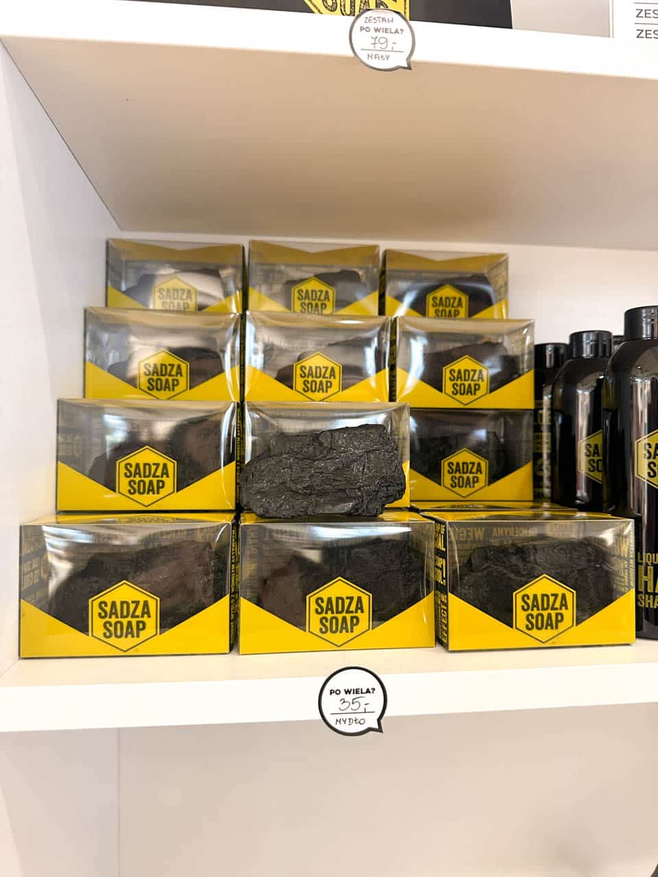 Boxes of Sadza Soap with a lump of black coal-like soap on display, stacked on a white shelf inside the Gryfnie shop in Katowice, Poland