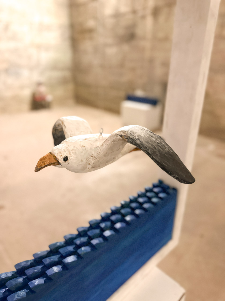 A handmade wooden seagull with black-tipped wings hanging inside the cellars of Diocletian's Palace in Split