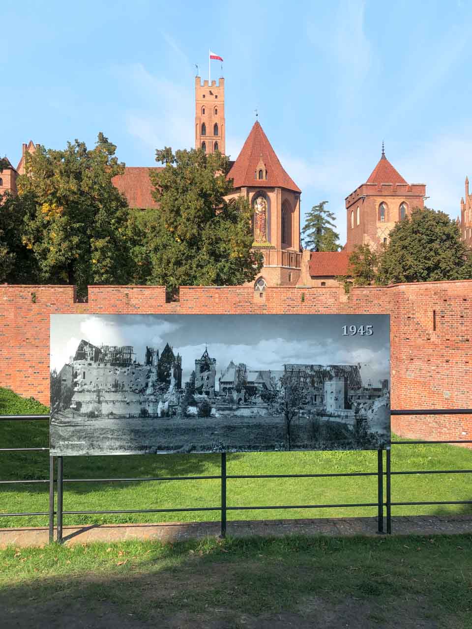 Historic photo from 1945 showing Malbork Castle in ruins, placed in front of the rebuilt site