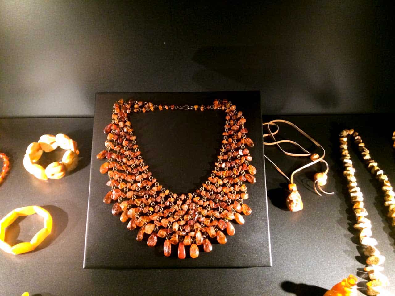 Display of amber jewellery including a chunky layered necklace, bangles, and pendants