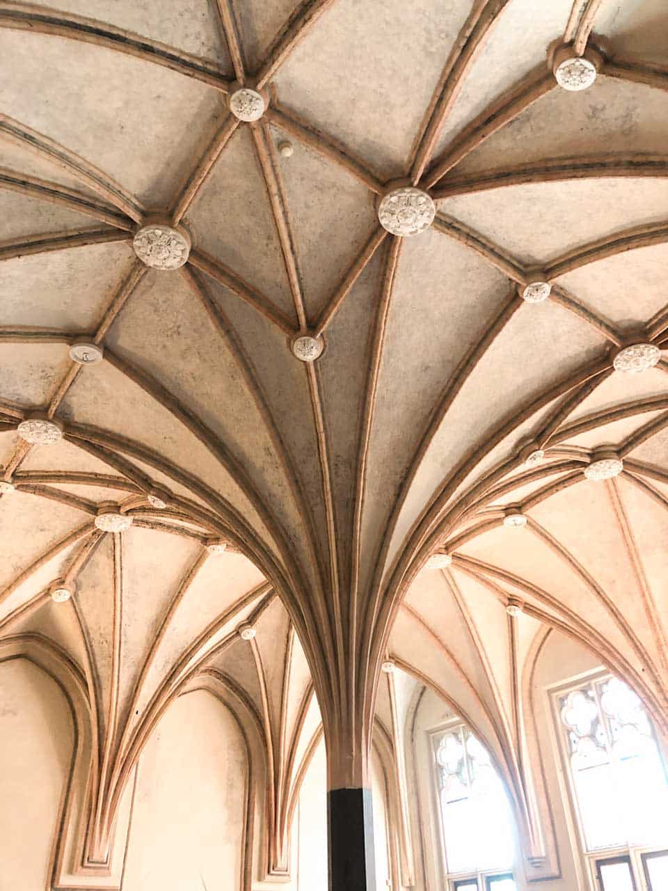Close-up of a vaulted ceiling with branching ribs and floral bosses inside Malbork Castle