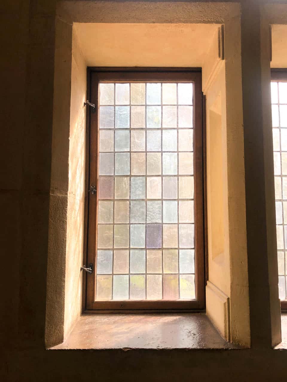 A frosted glass window with warm stone framing inside Malbork Castle