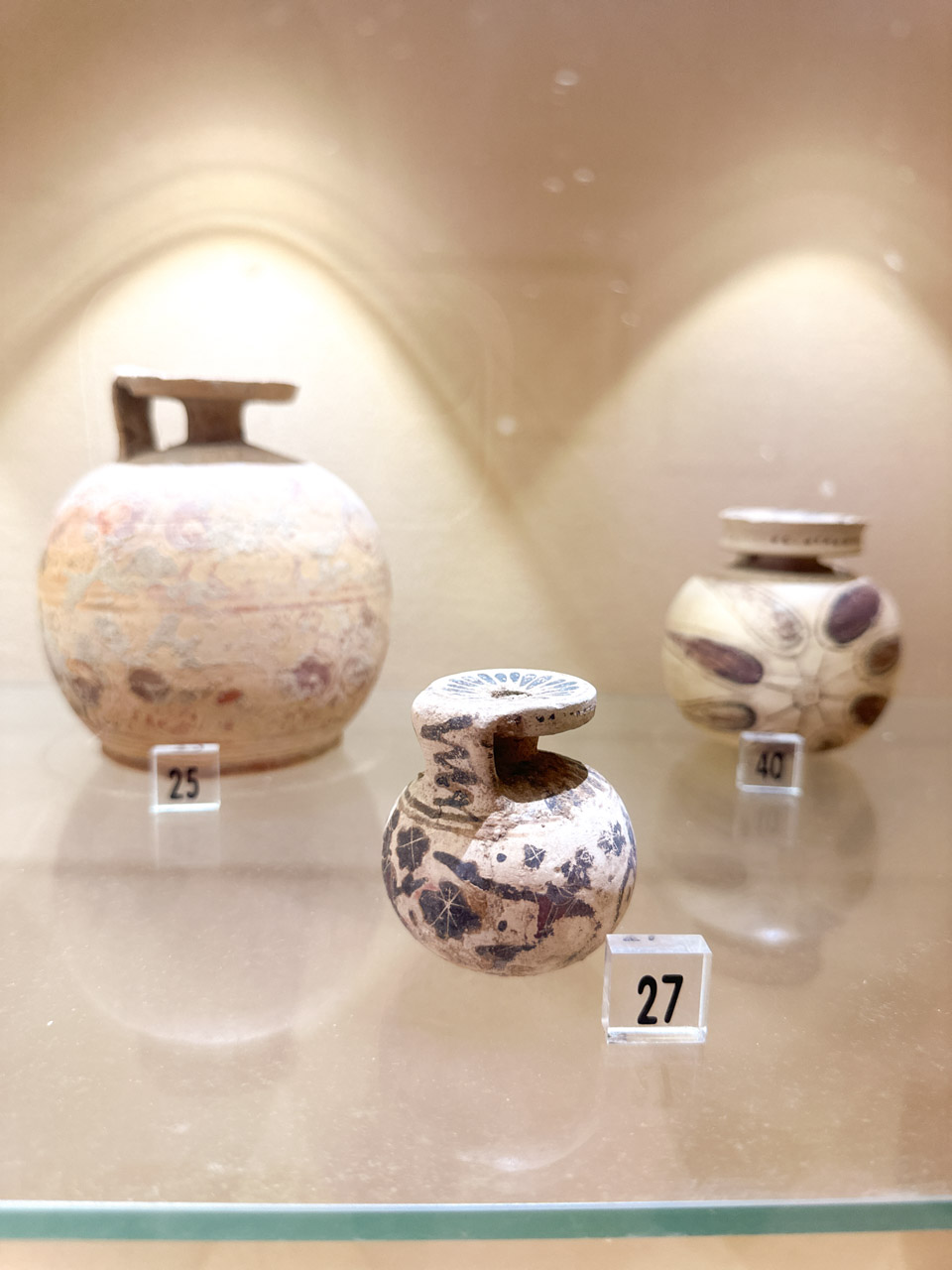 Three small ancient ceramic vessels displayed in a glass case at Brindisi’s archaeological museum