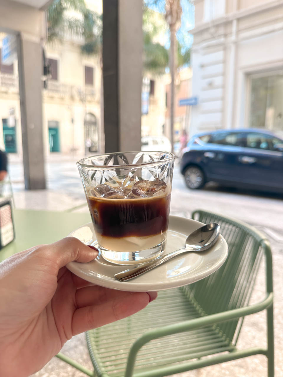 Glass of caffè Leccese served on a small saucer at Ausonia 1963 in Brindisi